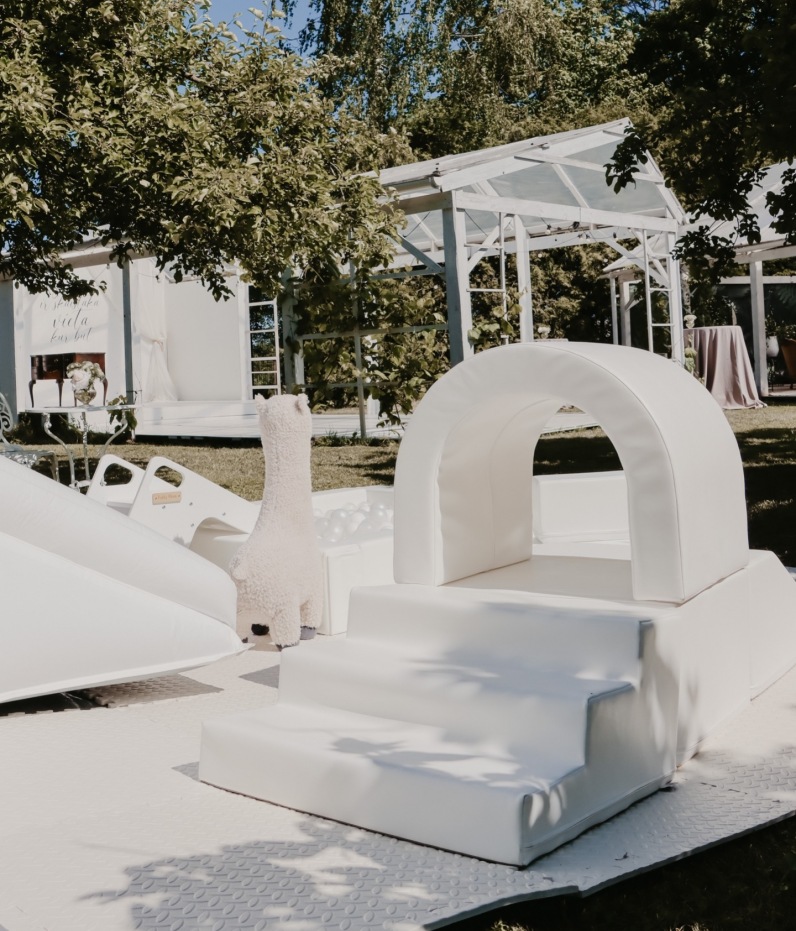 Gleznainā ainava ar zaļojošiem kokiem un krāsainiem ziediem rada romantisku atmosfēru, kuru ideāli papildina mūsu elegantās atrakcijas, ļaujot arī bērniem aizrautīgi izbaudīt šo dienu.